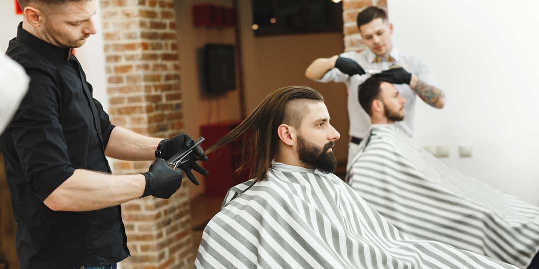 Barbers doing haircuts for clients