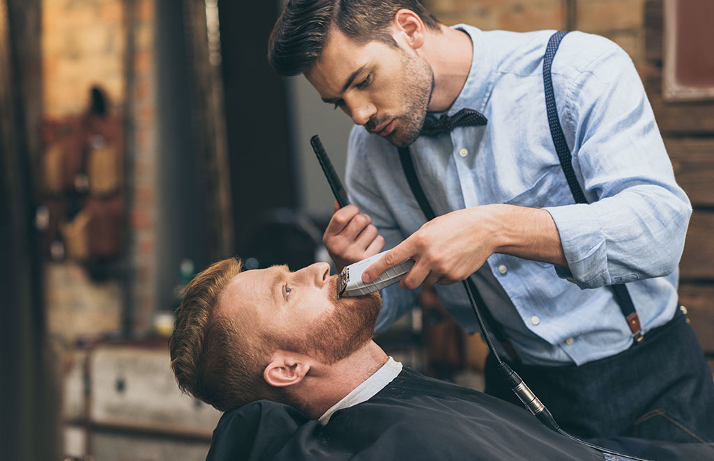 Barber trimming customers beard