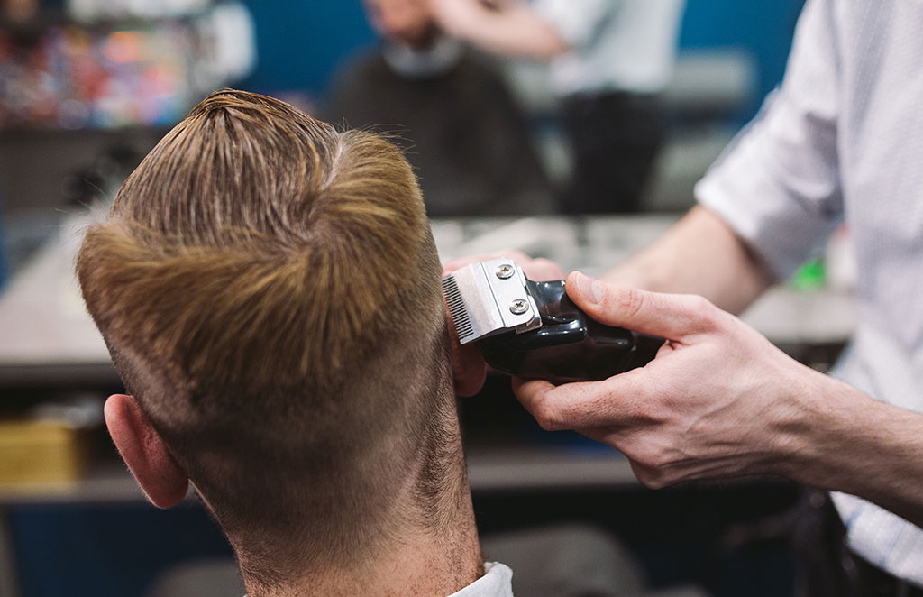 Man getting trendy haircut at barber shop