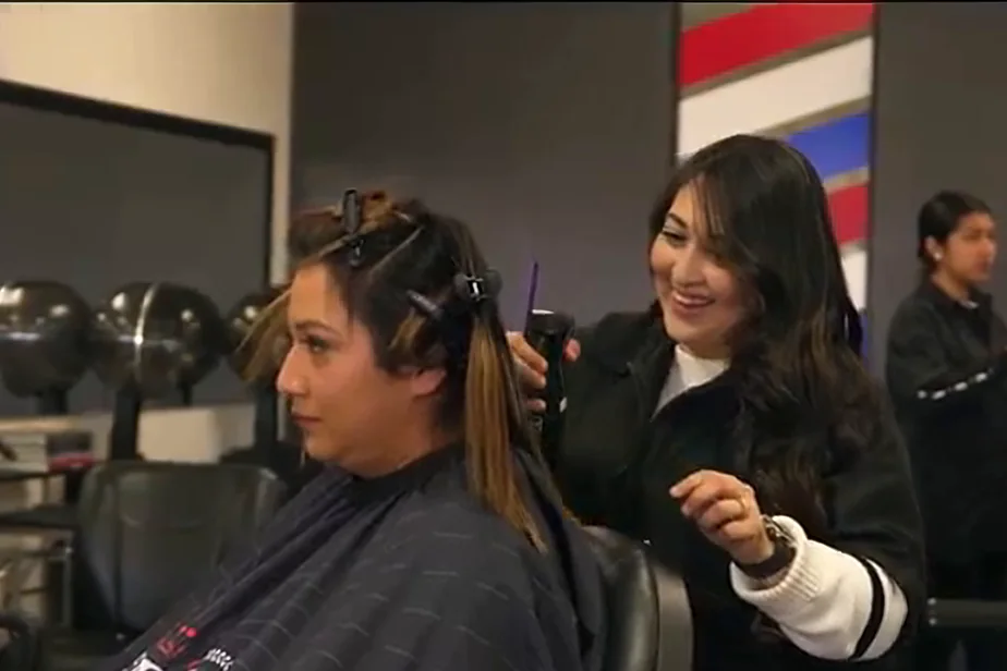 Cosmetology student applying foil highlights for a smiling client at SCCBB